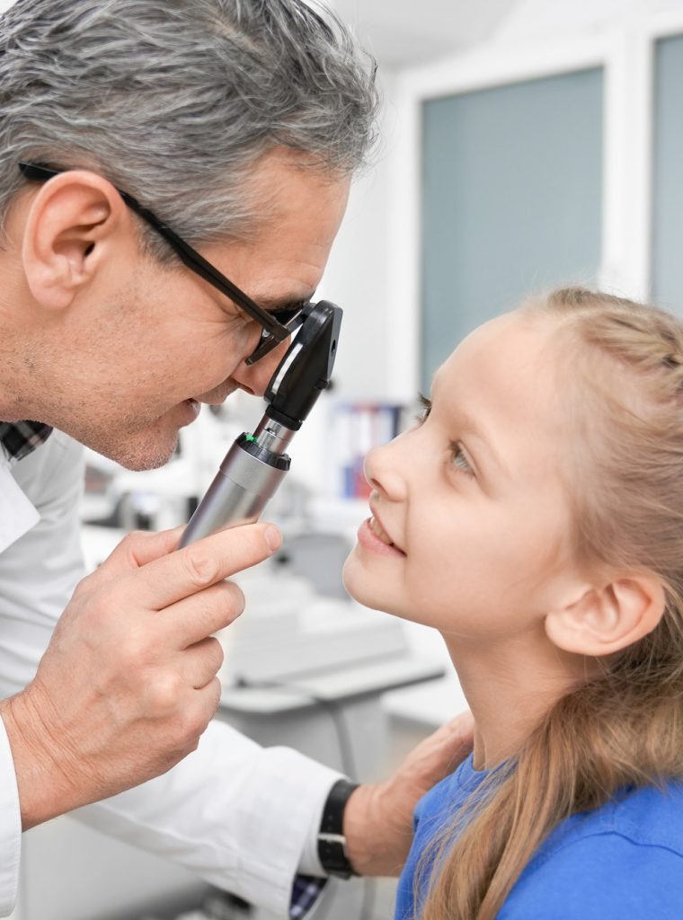 view-from-side-of-oculist-checking-sight-of-girl-in-clinic.jpg